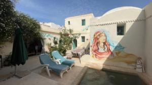 a painting of a woman on the side of a building at Dar Lily in Erriadh
