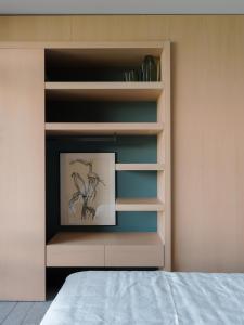 uma estante de livros com um quadro num quarto em LARIUM BED & BREAKFAST - PIGRA em Pigra
