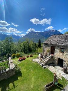 a stone house with mountains in the background at Casa Brencio in Masera