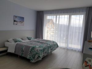 a bedroom with a bed and a large window at Apartament Czarna Góra Faktura VAT in Sienna