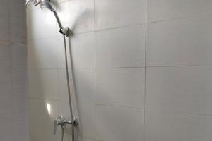 een douche met een douchekop in de badkamer bij KoolKost near Millennium ICT Center Medan (Minimum Stay 6 Nights) in Pulauberayan