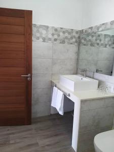 a bathroom with a sink and a mirror and a toilet at Villa Trochetia in La Gaulette