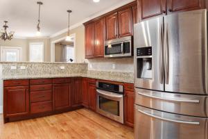 una cucina con armadietti in legno ed elettrodomestici in acciaio inossidabile di Premium WIFI! Luxurious Home in ASHEVILLE with PRIVATE Hot tub! ad Asheville