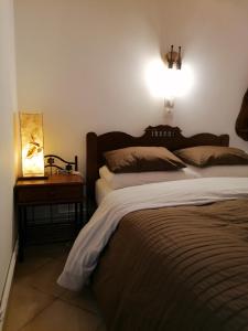 a bedroom with a bed and a table with a lamp at Ξενώνας Το Πατρικό in Synikia Mesi Trikalon