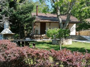 ein Haus mit einem Picknicktisch im Hof in der Unterkunft Ξενώνας Το Πατρικό in Karya