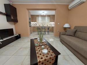 uma sala de estar com um sofá e uma mesa em Litsa Galaxy Apartment em Artemida