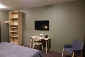 Habitación con cama, mesa y TV. en Basalt Hotel en Borgarnes