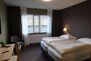 Habitación de hotel con 2 camas y ventana en Basalt Hotel, en Borgarnes