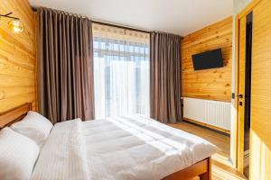 um quarto com uma cama e uma grande janela em Comfort House em Bukovel
