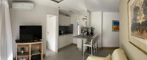 uma sala de estar com televisão e uma cozinha em Appartement proche mer et gare em Cannes