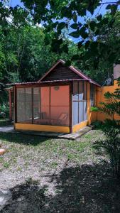 una pequeña casa con una gran ventana en un patio en Ecohabitat, en Xpujil