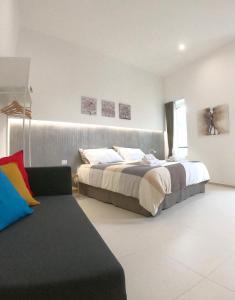 sypialnia z 2 łóżkami i kanapą w obiekcie Home Catania Dante Accommodations w Katanii