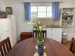 una cocina con una mesa de madera y un jarrón con flores. en Rondebossie Farm Retreat, en Magoebaskloof