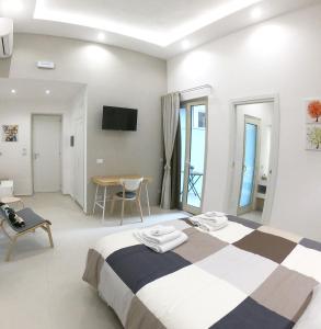 biały pokój z łóżkiem i stołem w obiekcie Home Catania Dante Accommodations w Katanii