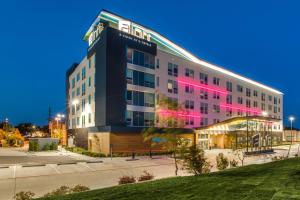 a hotel building with pink lights in front of it at Aloft Dallas Arlington Entertainment District in Arlington