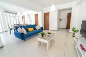 a living room with a blue couch and a table at Jana's 2-BR Apartment in Larnaca in Larnaka