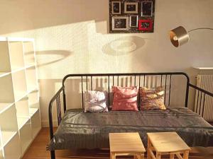 a bedroom with a bed with two tables and a lamp at Renovated, 37m², 2 min walk Tram, 5 min La Défense in La Garenne-Colombes +2 photos