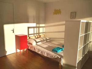 1 dormitorio pequeño con 1 cama y armario rojo en Renovated, 37m², 2 min walk Tram, 5 min La Défense, en La Garenne-Colombes
