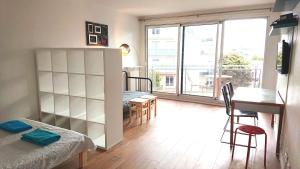 Habitación con cama, mesa y comedor. en Renovated, 37m², 2 min walk Tram, 5 min La Défense, en La Garenne-Colombes