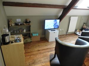 a living room with a flat screen tv and chairs at hoeve onder de eik in Jabbeke