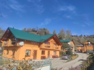 a large wooden house with a green roof at Приватна садиба "Гереджука" in Vorokhta +28 photos