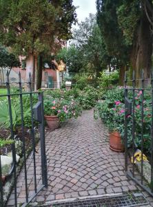 a garden with a gate with flowers and plants at La Lampara in Sirmione
