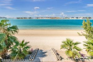 a view of a beach with palm trees and the ocean at Dream Inn - Signature Villa in Dubai