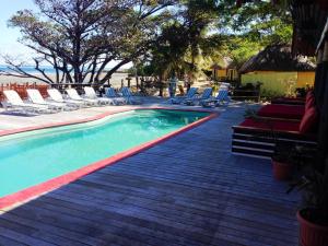 a swimming pool with lounge chairs and the ocean at Funky Fish Beach & Surf Resort in Malolo
