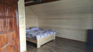 sypialnia z łóżkiem w drewnianym pokoju w obiekcie Приватна садиба "Гереджука" w mieście Worochta