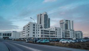 a parking lot with cars parked in front of tall buildings at Apartament AQUAROOM Reda in Reda