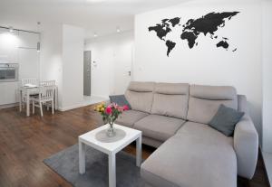 een woonkamer met een bank en een wereldkaart aan de muur bij Apartament AQUAROOM Reda in Reda