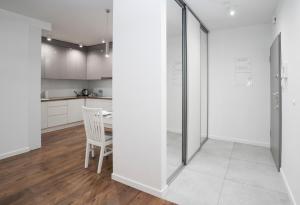 a kitchen with white walls and a table and a chair at Apartament AQUAROOM Reda in Reda