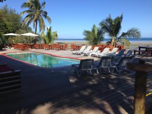 a swimming pool with lounge chairs and the beach at Funky Fish Beach & Surf Resort in Malolo