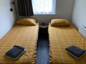 two beds sitting next to each other in a room at De Deelderij in Schoonloo