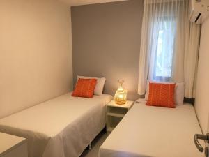 嘎林海斯港的住宿－Privê Portal do Sol，带窗户的客房内的两张床