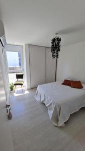 ein weißes Schlafzimmer mit einem Bett und einem Fenster in der Unterkunft Depto 44 in La Plata