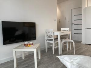 een woonkamer met 2 tafels en een flatscreen-tv bij Apartment Rzeszów Karolina in Rzeszów