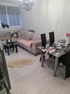 ein Wohnzimmer mit einem Sofa, einem Tisch und Stühlen in der Unterkunft Apartament przy Kopalni Złota in Złoty Stok