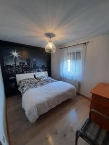 um quarto com uma cama branca e um lustre em Apartament Kwiatowa em Piechowice