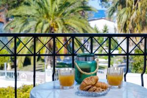 een tafel met twee glazen sinaasappelsap en een kom koekjes bij Eleani Hotel in Prinos