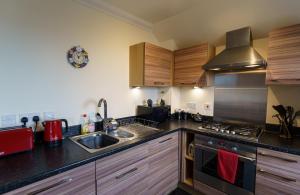 una cocina con fregadero y estufa horno superior en Lossiemouth Haven, en Lossiemouth