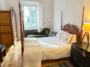 a bedroom with a large bed and a chair at Casa Didi, Sintra by Trip2Portugal in Sintra