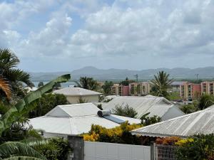 - une vue sur une ville avec des bâtiments et des palmiers dans l'établissement TURQUOISE CARAIBES, à Les Trois-Îlets