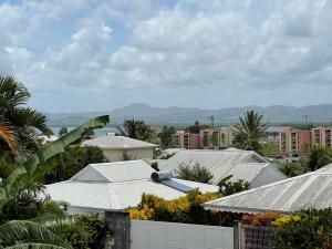 a view of a city with buildings and palm trees at TURQUOISE CARAIBES in Les Trois-Îlets