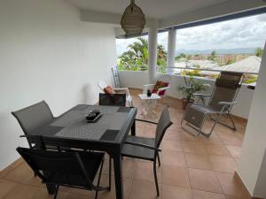 a dining room with a table and chairs at TURQUOISE CARAIBES in Les Trois-Îlets