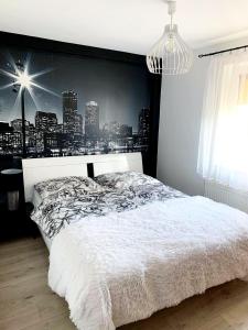 um quarto com uma cama branca com um pano de fundo da cidade em Apartament Kwiatowa em Piechowice