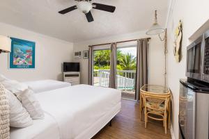 a bedroom with two beds and a balcony at Gulf View Waterfront Resort in Marathon