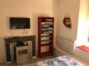 Zimmer mit einem Bett und einem TV an der Wand in der Unterkunft Chez Julien: appartement confort plein centre in Lunéville