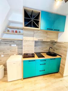 eine Küche mit blauen Schränken und einem Waschbecken in der Unterkunft Divcibarski cardak in Divčibare