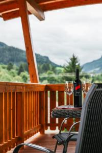 a table with a bottle of wine and two glasses on a deck at Siegi's Apartments in Hof